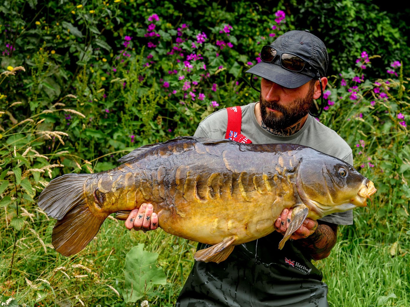 Man holds a freshly caught carp at SWS fisheries.