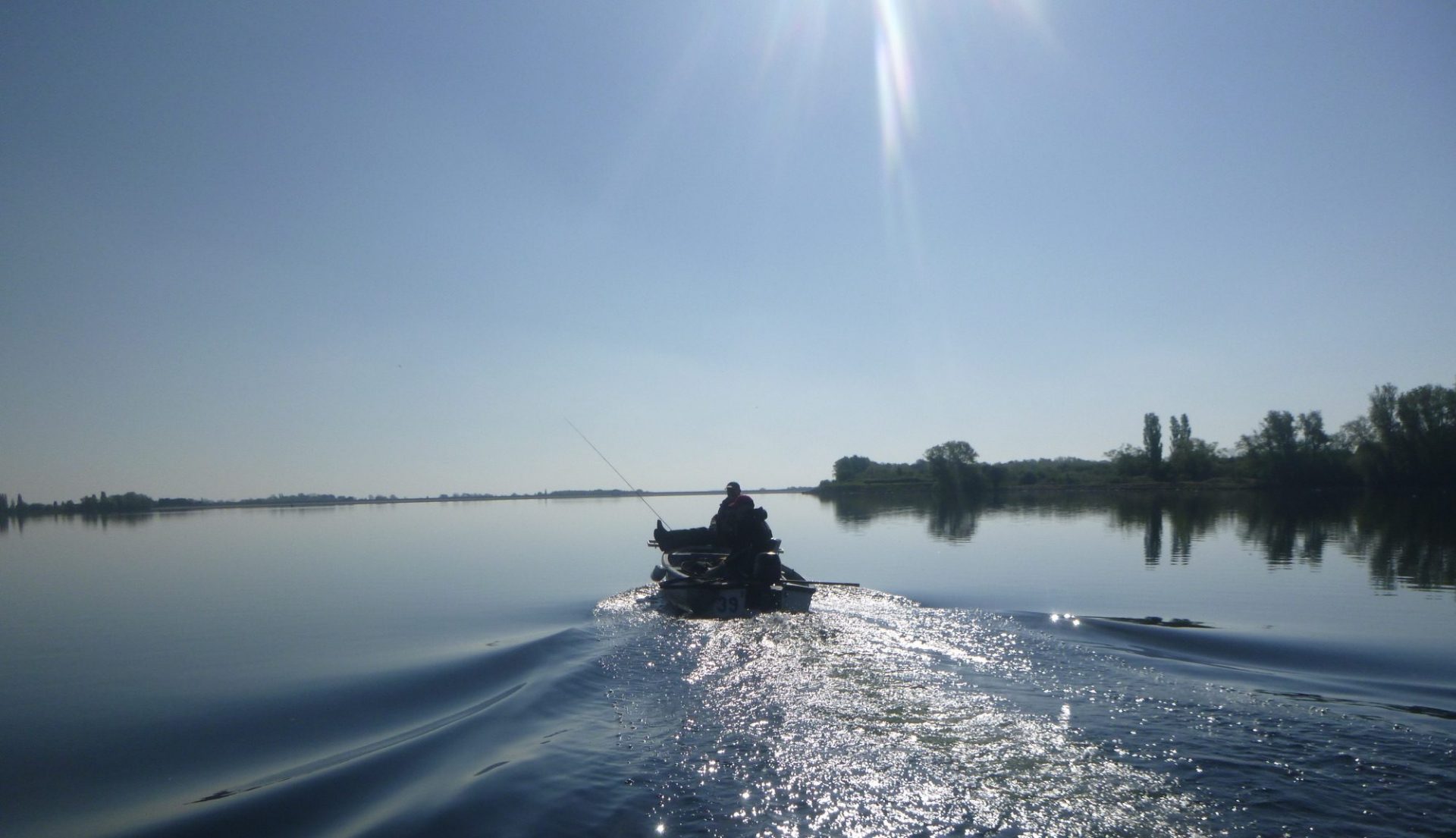 Man fishes from a small boat on Grafham Water after buying a membership online using Clubmate