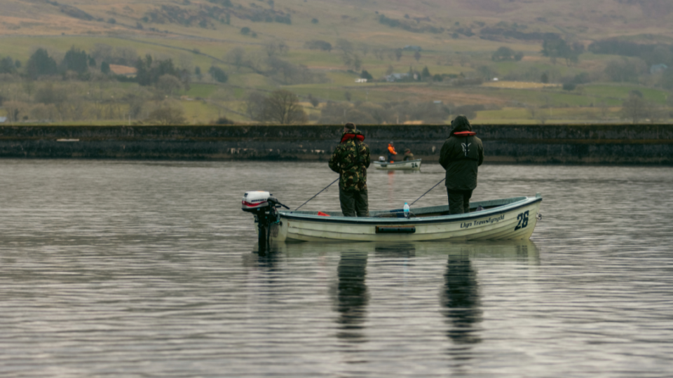 Anglers fish standing up in a boat at their local fishing club.