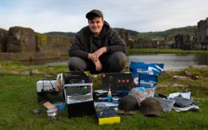 Angling influencer poses with a collection of gifted tackle.