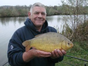 Angler poses with a recent catch at Goldaming Angling Society, one of the most popular fishing clubs in the South East of England.