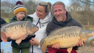 Manchester Angling Club manager Jamie with young family showing off their catch